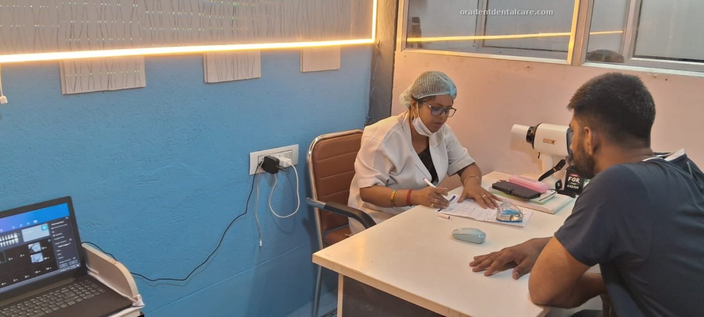 Dentist talking with a patient across the consultation desk before treatment at ORADENT Dental Care