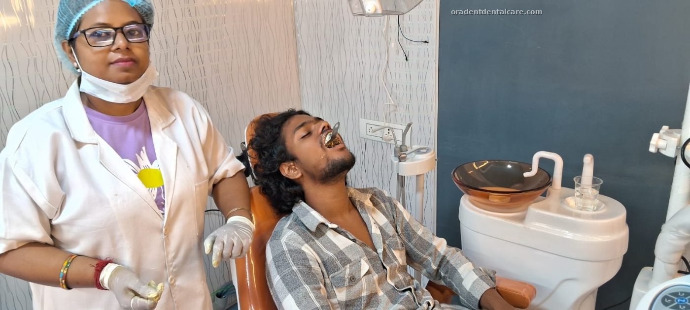Dentist standing beside a patient in the dental chair at ORADENT Dental Care