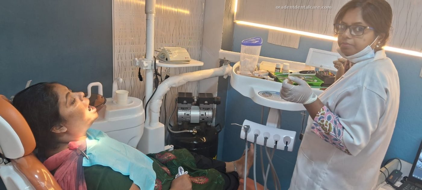 Dentist treating a patient in the dental chair at ORADENT Dental Care