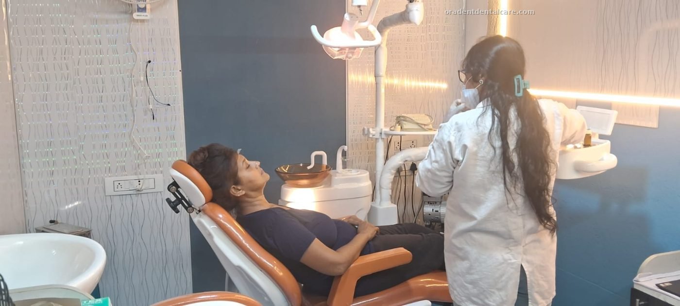Dentist attending to a patient lying back in the dental chair at ORADENT Dental Care