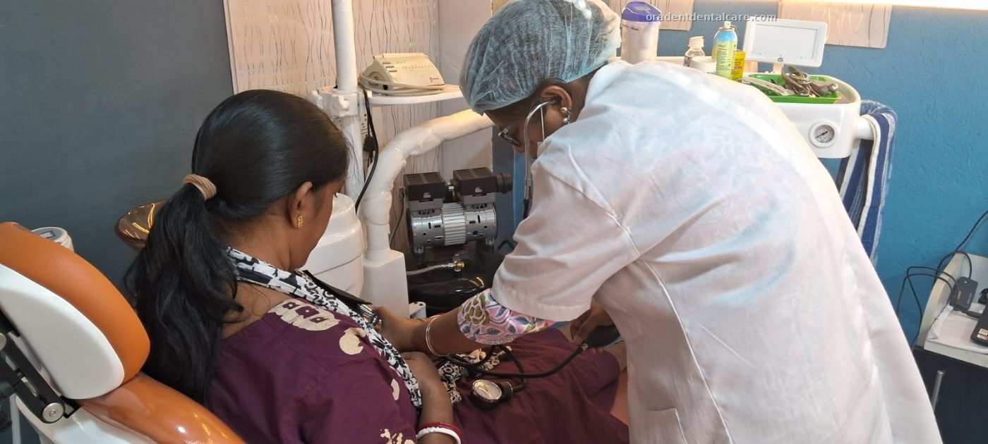 Dentist treating a patient in the dental chair at ORADENT Dental Care